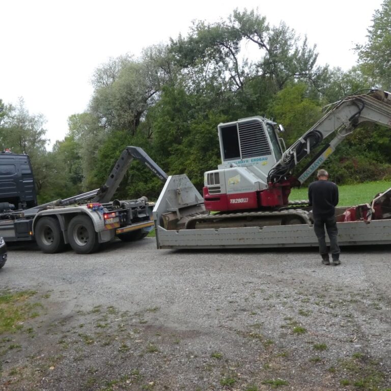 Der Bagger wird bei der Vereinshütte vom Tieflader abgeladen
