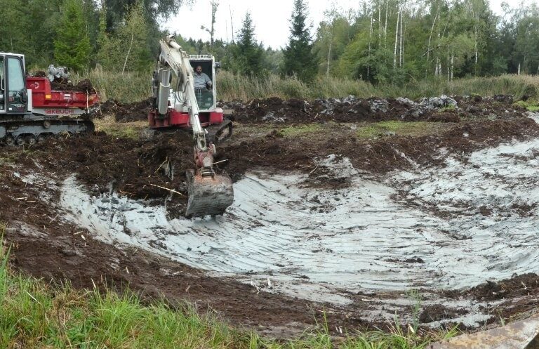 Blick über die Baugrube mit Raupendumper und Bagger