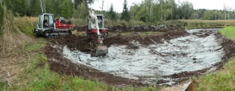 Blick über die Baugrube mit Raupendumper und Bagger