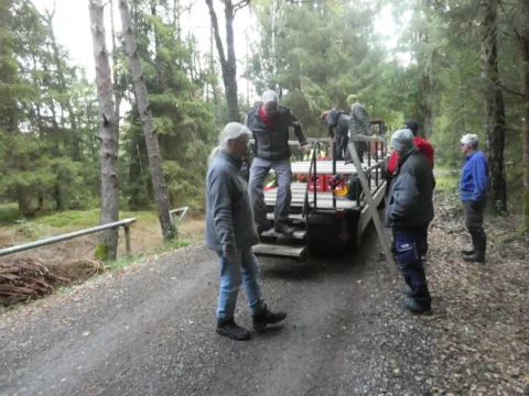Auf einem Forstweg steigt die Mannschaft auf den Anhänger